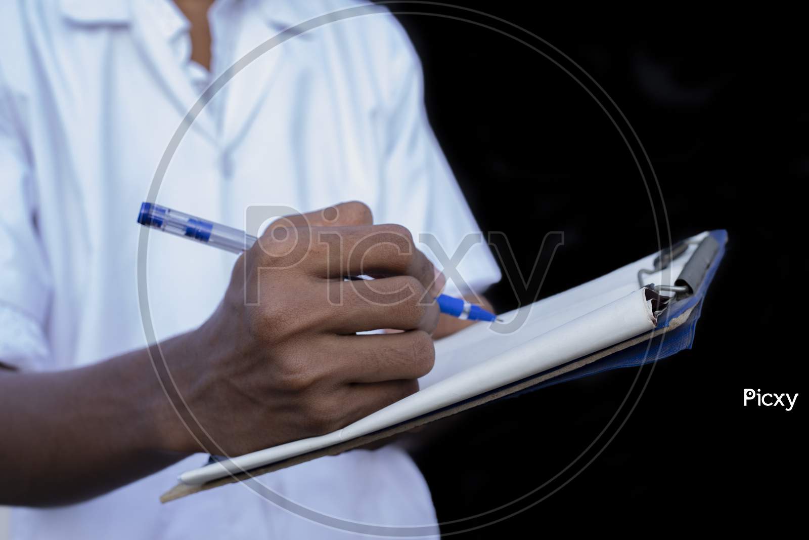 Male Doctor Noting A Medical Check Up Information In Black Backgrounds