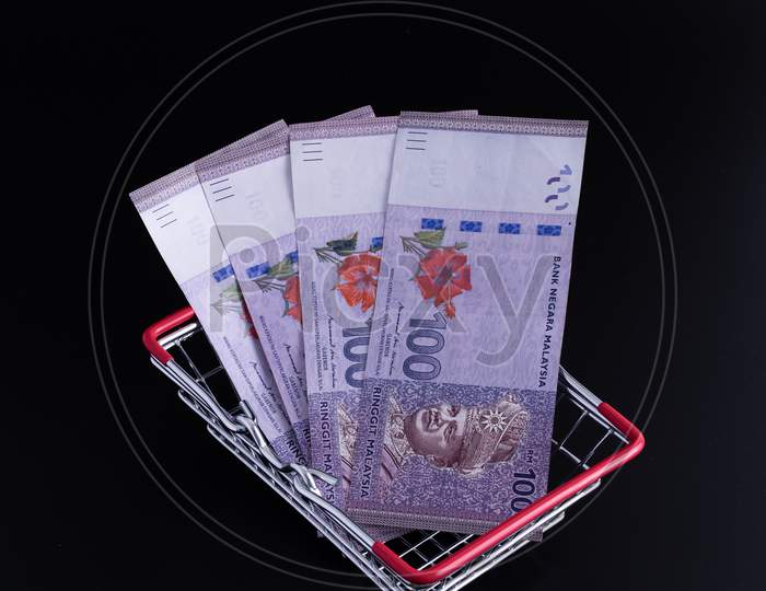 Banknotes Malaysia Currency Inside A Shopping Cart On A Black Background.