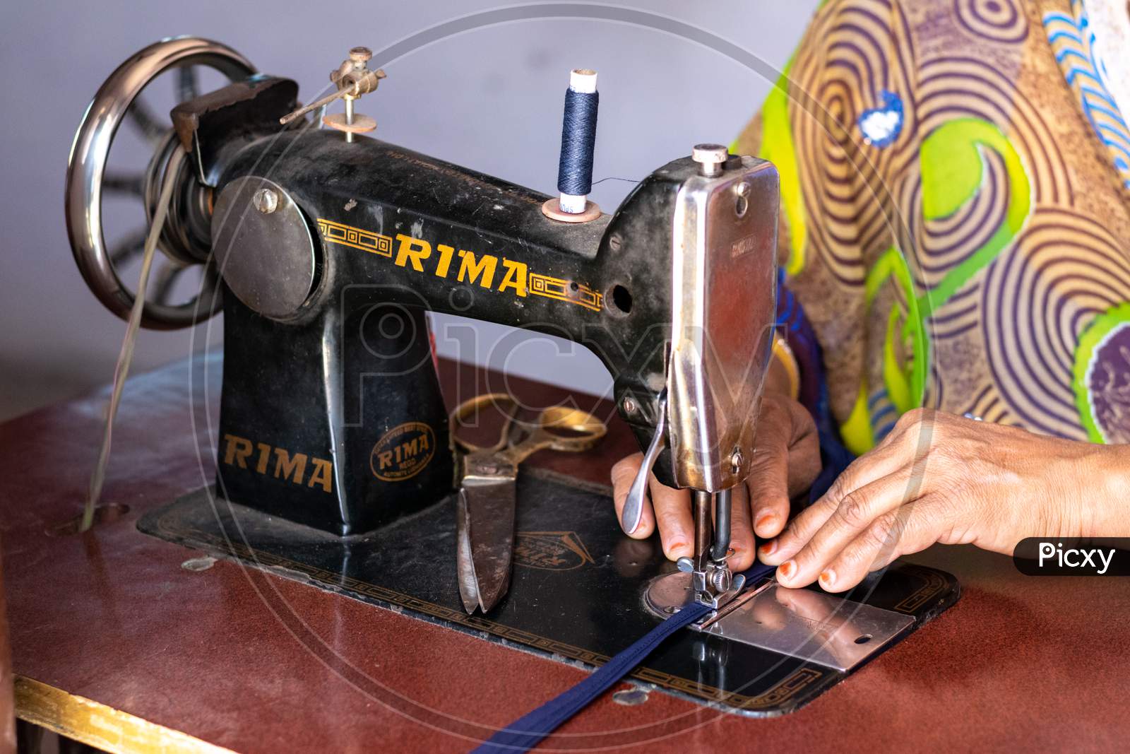 A woman working on sewing machine at home