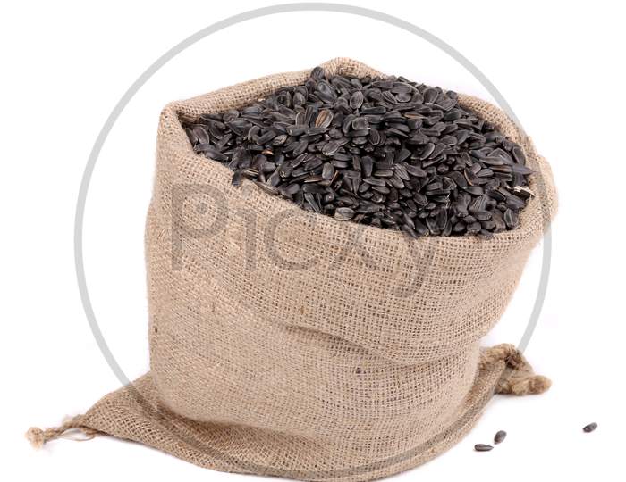 Close Up Of Black Sunflower Seeds In Bag. Isolated On A White Background.