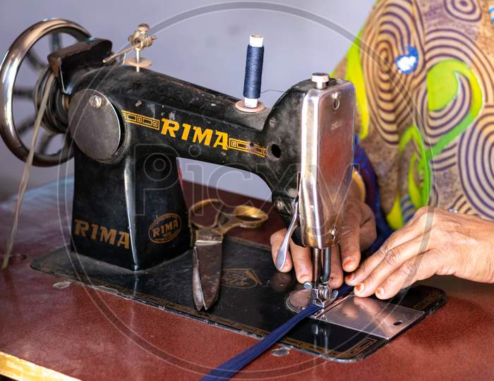 A woman working on sewing machine at home