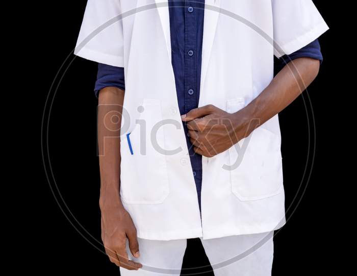 Cropped Portrait Of A Young Male Doctor With Hands Holding White Coat On A Black Background