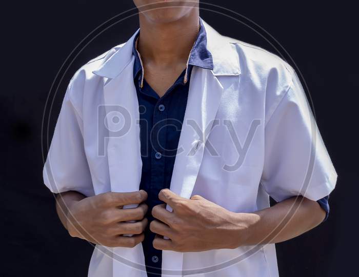 A Close-Up Cropped Portrait Of A Male Doctor Holding A White Coat Isolated On A Black Backgrounds