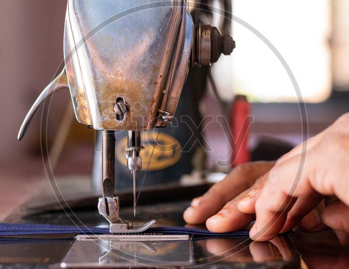 A woman working on a sewing machine at home closeup