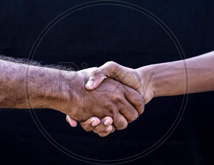 People Concepts. Two Men Shaking Hands Isolated On Black Backgrounds
