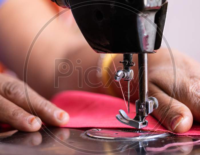 A woman sewing clothes on sewing machine at home Closeup