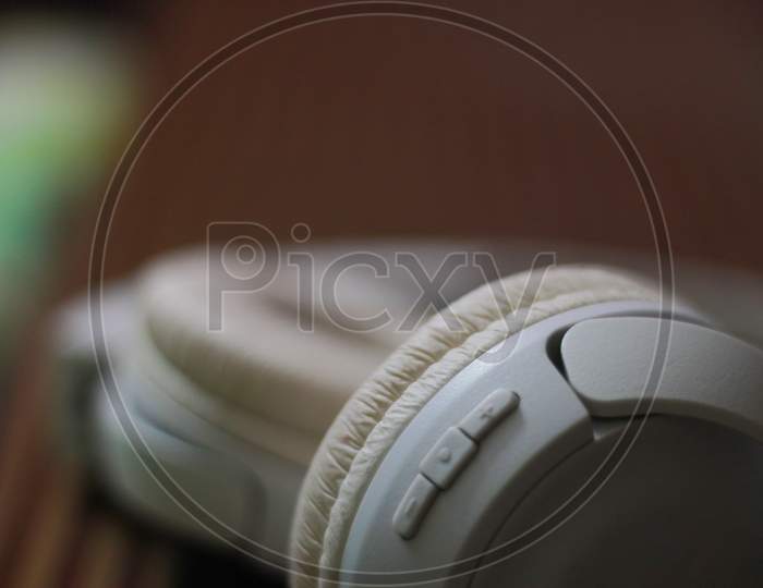 a closeup of a white bluetooth headphone