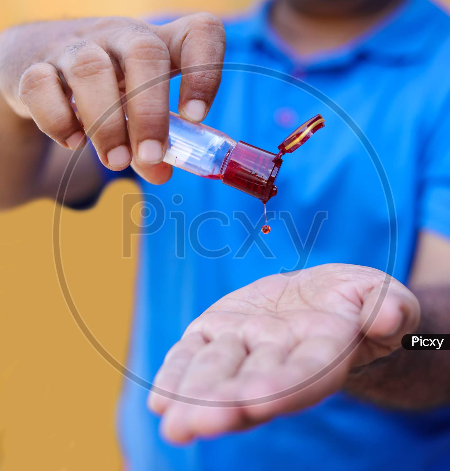 Skin Care And Treatment - Man Pouring Oil In A Hand On Yellow Backgrounds