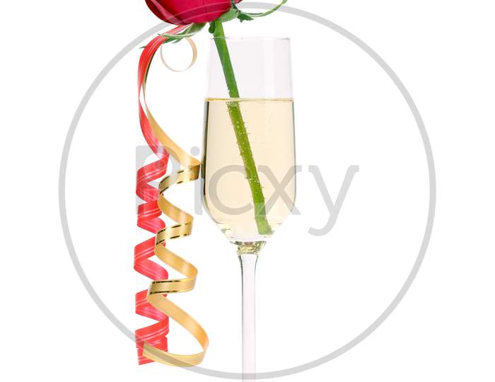 Red Rose In Glass Of Champagne And Paper Streamer. Isolated On White Background.