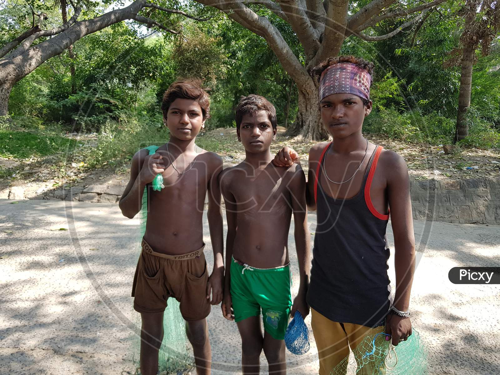 Krishnagiri, Tamil Nadu, India - 23-Dec-2018: Three young boys from the fisherman community in Tamil nadu posing with their nets