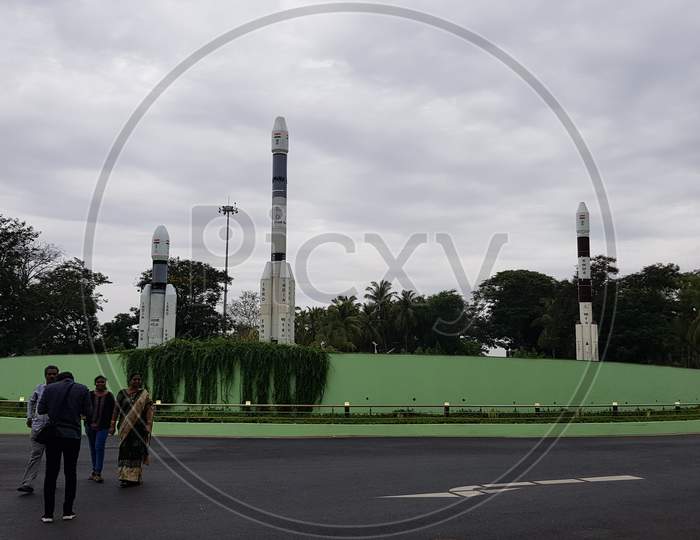 Sriharikota, Andhra Pradesh, India - July 22 2019: Visitors at the entrance of 'Satish Dhawan Space Research Center' that belongs to ISRO on a cloudy day with the mock rockets in the background