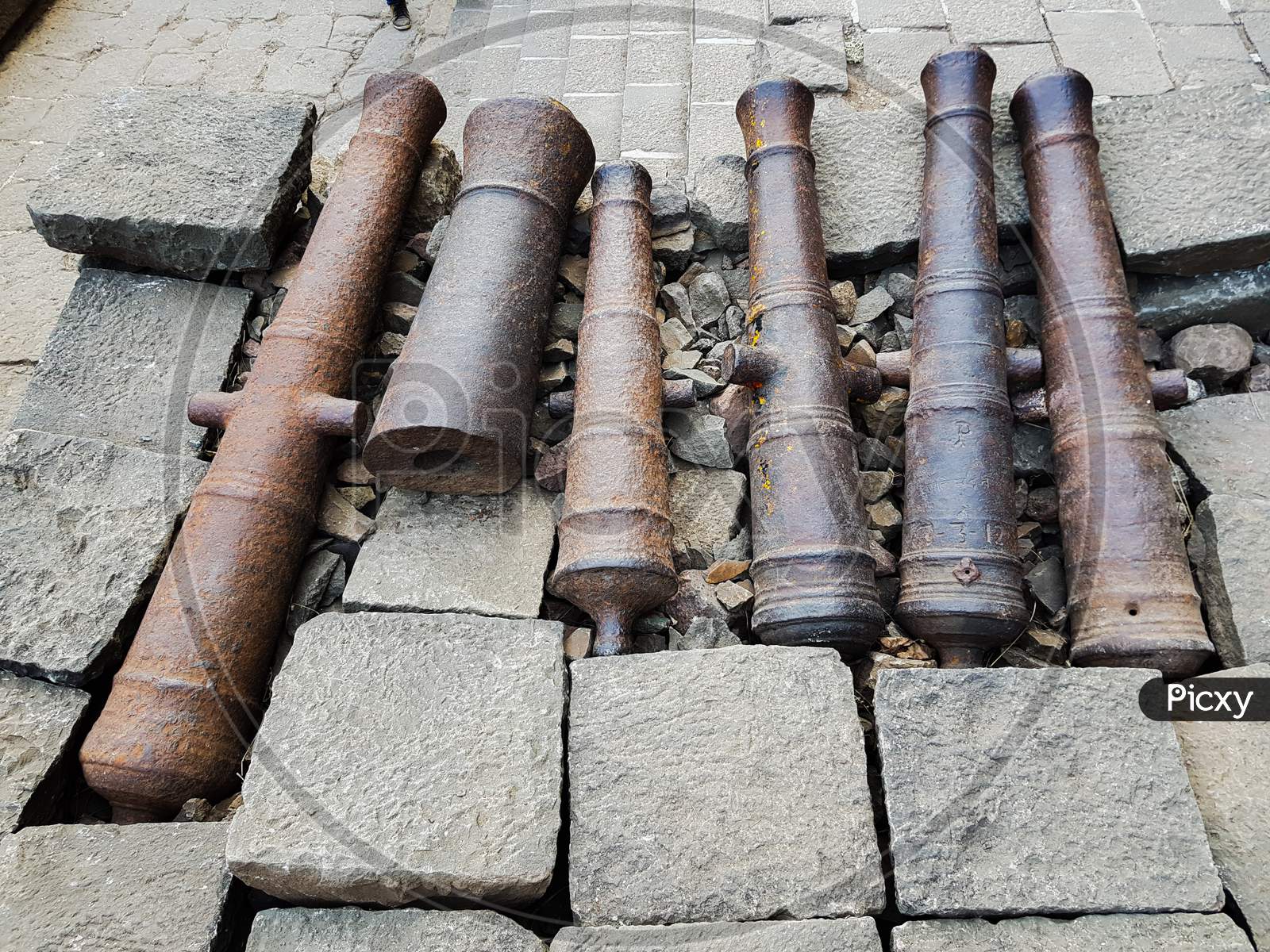 Medium closeup shot of ancient cast iron canons lying on the ground