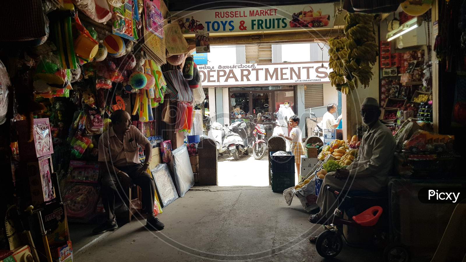 Bengaluru, Karnataka / India - August 16 2019: Two shopkeepers sitting at the entrance of Russel market