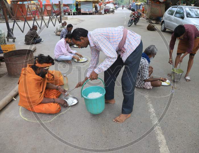 Homeless People Site Inside Circles Drawn On A Road For People To Maintain Safe Distance To Eat Food During A 21-Day Nationwide Lockdown To Slow The Spreading Of Coronavirus Disease (Covid-19) In Prayagraj, April 8, 2020.