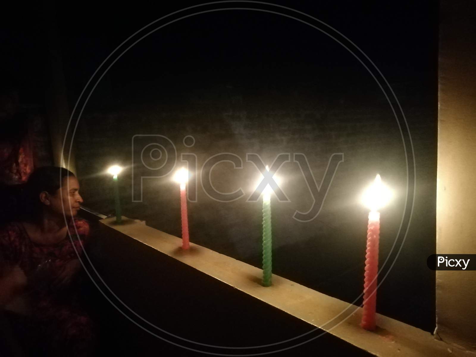 Row of Candles lit in a row on a wall on 5th April 2020 to fight against Covid-19 Corona virus