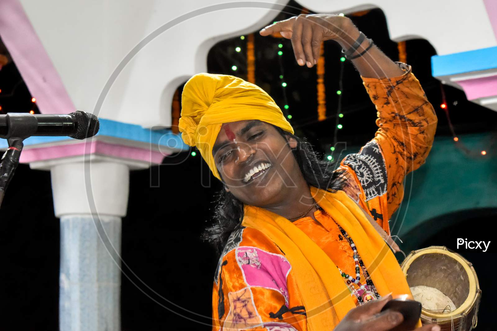A folk singer of West Bengal performing folk songs on the stage with his local string instrument