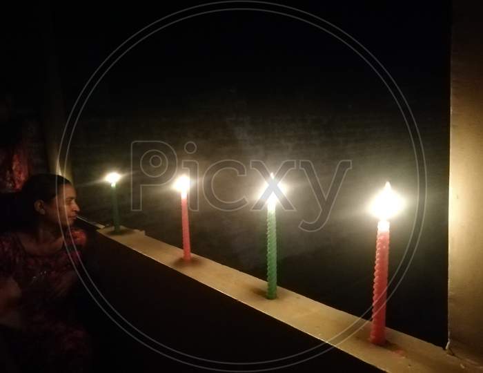 Row of Candles lit in a row on a wall on 5th April 2020 to fight against Covid-19 Corona virus