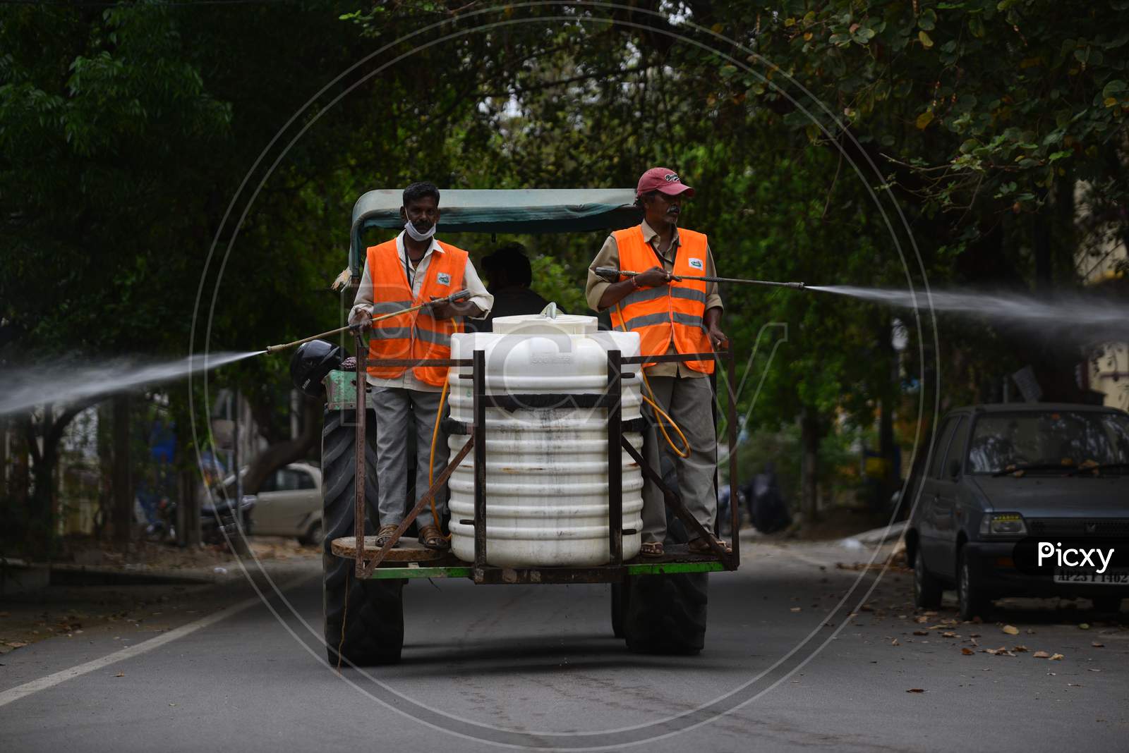 Disinfectant (Sodium Hypochlorite) being sprayed in streets by GHMC Sanitation workers using motors fixed to tractors to prevent the spread of coronavirus, covid19 during the nationwide lockdown