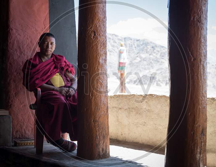 LEH, LADAKH, JAMMU AND KASHMIR, AUGUST 21 2017: A monk sitting in the balcony of Thiksey monastery, Ladakh, India