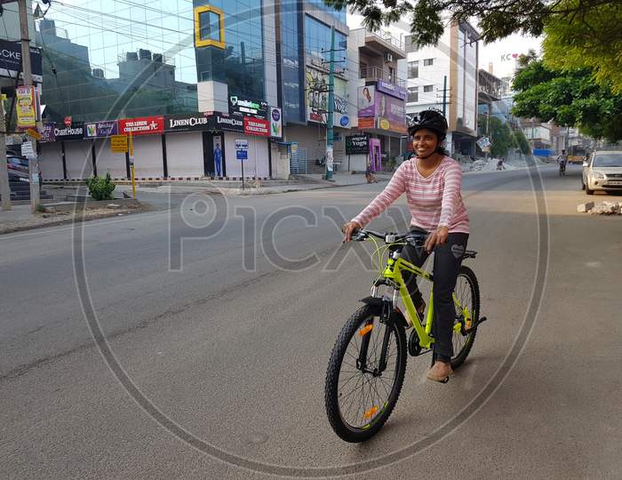 Bangalore, Karnataka, India - 1-April-2018: A woman cycling on the road early in the morning on an empty road in Bangalore, Karnataka, India