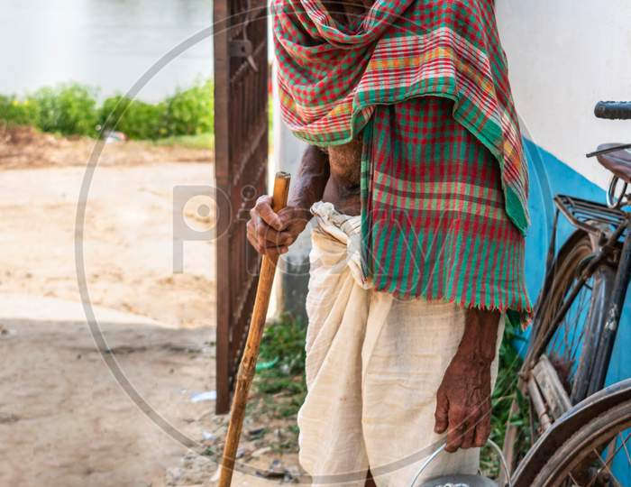 Serious native Indian old man with walking stick looking at camera