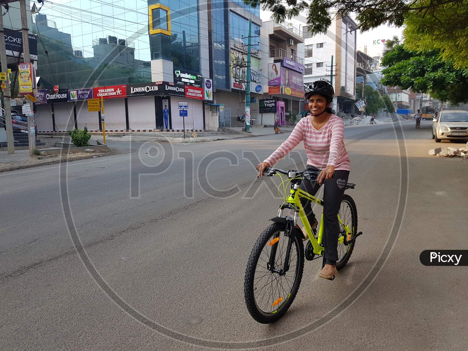 Bangalore, Karnataka, India - 1-April-2018: A woman cycling on the road early in the morning on an empty road in Bangalore, Karnataka, India
