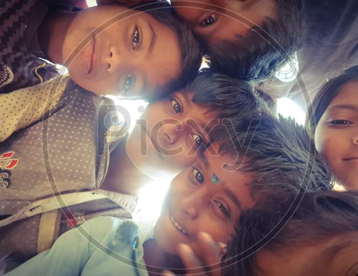 Bengaluru, Karnataka / India - August 02 2019: A group of small children huddled up and looking into the camera