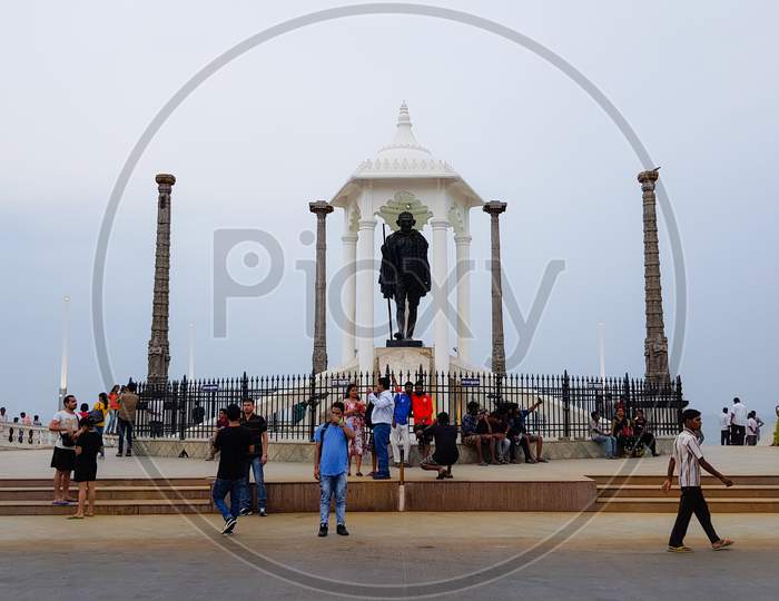 Pondicherry, India - 11 August 2018: Tourists walking near the Gandhi statue at Gandhi beach in Pondicherry 
