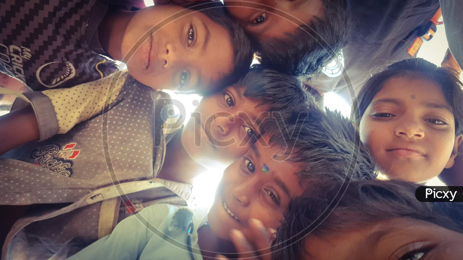 Bengaluru, Karnataka / India - August 02 2019: A group of small children huddled up and looking into the camera