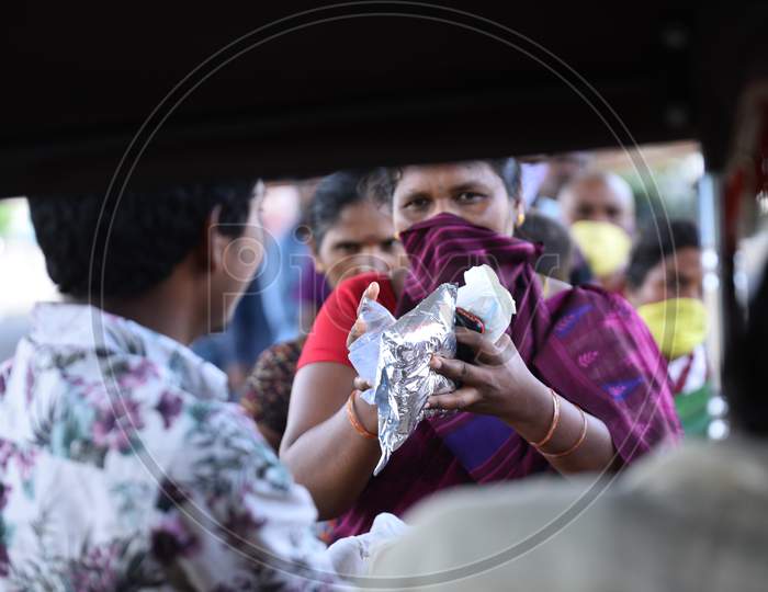 a migrant worker woman collects food packets being distributed by donors as they couldn't find food and work during nationwide lockdown amid coronavirus pandemic, April 8,2020, Hyderabad.