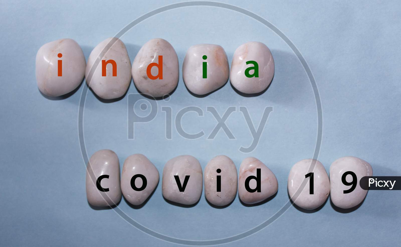 Concept Coronavirus. India Covid 19 As A Text With Letters On White Royal Sapphire Rock Pebbles, Template Against A Blue Background