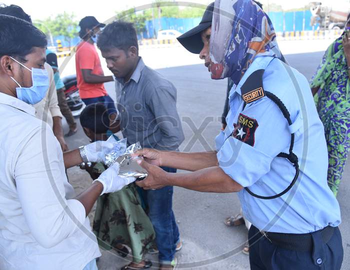 a migrant worker who works as a security guard collects food packets being distributed by some donors as they couldn't find food and work during nationwide lockdown amid coronavirus pandemic, April 8,2020, Hyderabad.