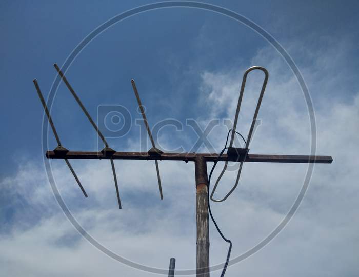 A TV antenna with blue sky, in day time