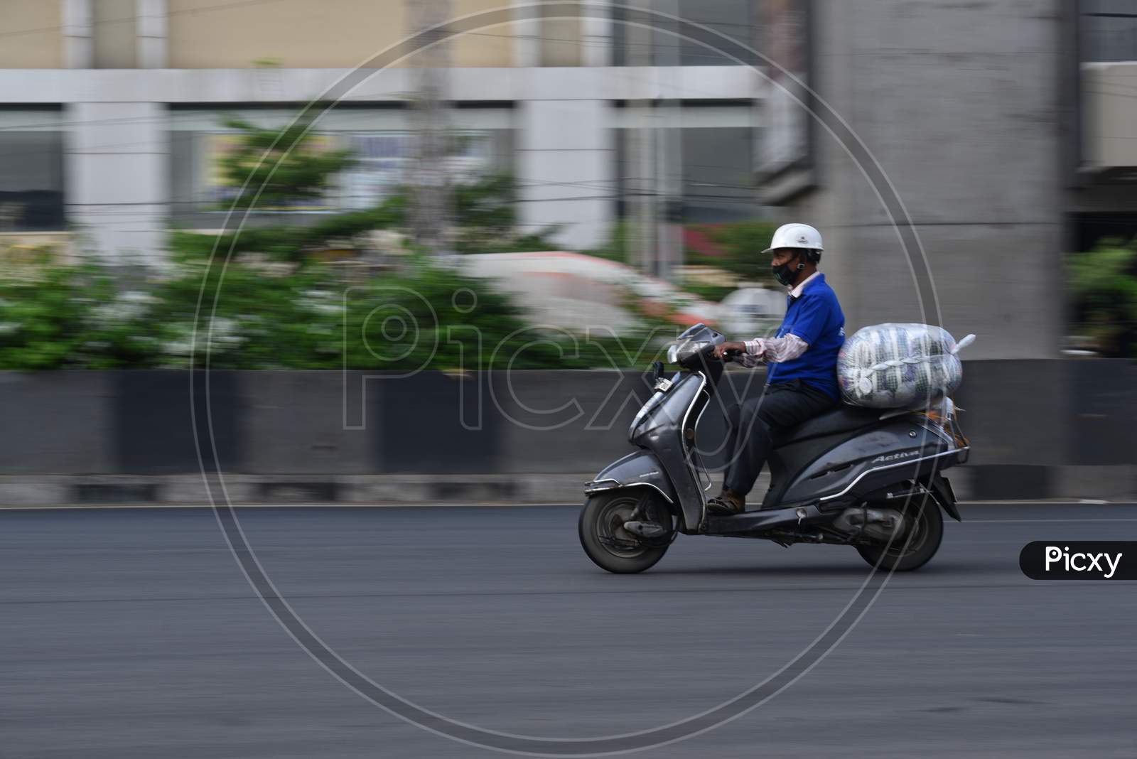 a man delivers essential groceries on his bike during nationwide lockdown amid coronavirus pandemic, April 8,2020, Hyderabad.