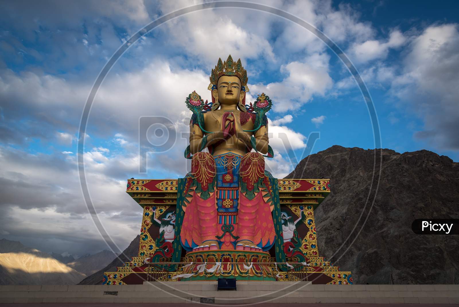 Maitrey Buddha Statue at Diskit Monastery with mountains and sky in the background, Nubra Valley, Ladakh, India
