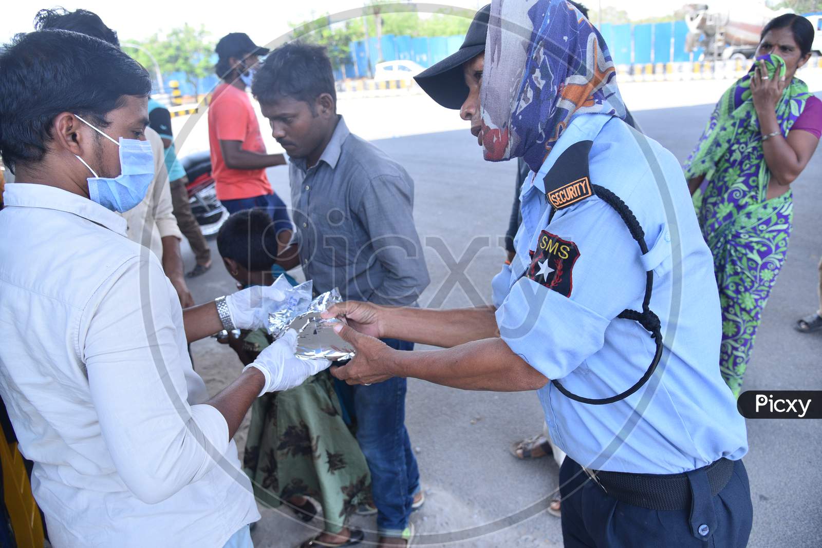 a migrant worker who works as a security guard collects food packets being distributed by some donors as they couldn't find food and work during nationwide lockdown amid coronavirus pandemic, April 8,2020, Hyderabad.