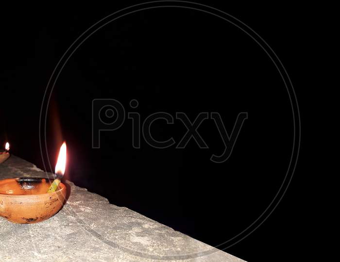 A burning clay lamp filled with mustard oil - Diwali celebration in black background