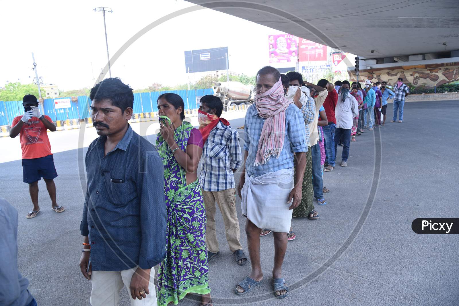 a migrant workers wait in line to collect food packets being distributed by some donors as they couldn't find food and work during nationwide lockdown amid coronavirus pandemic, April 8,2020, Hyderabad.