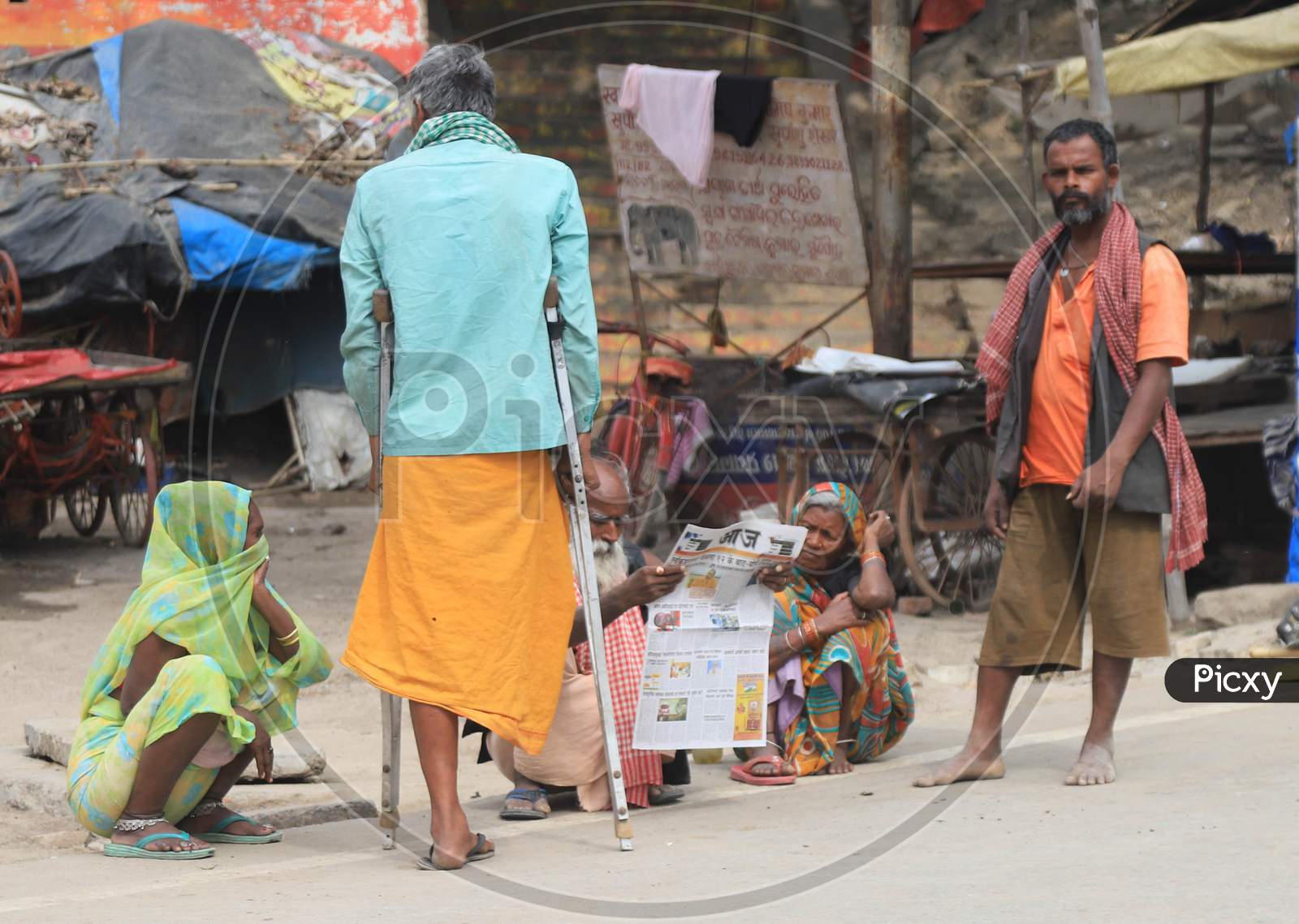 Homeless People Reading News Paper During A 21-Day Nationwide Lockdown To Slow The Spreading Of Coronavirus Disease (Covid-19) In Prayagraj, April 9, 2020.