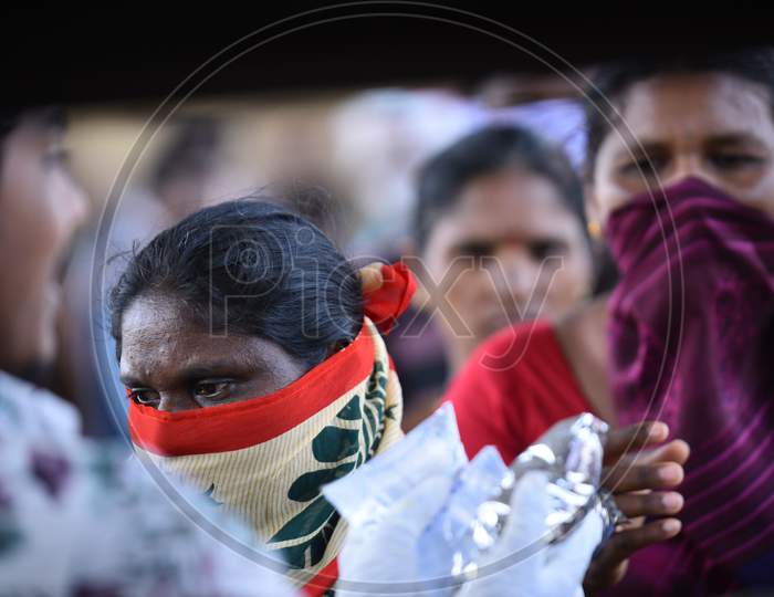 a migrant workers wait in line to collect food packets being distributed by donors as they couldn't find food and work during nationwide lockdown amid coronavirus pandemic, April 8,2020, Hyderabad.