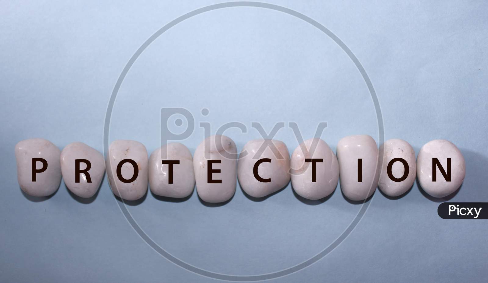 Concept Coronavirus. Protection As A Text With Letters On White Royal Sapphire Rock Pebbles, Template Against A Blue Background