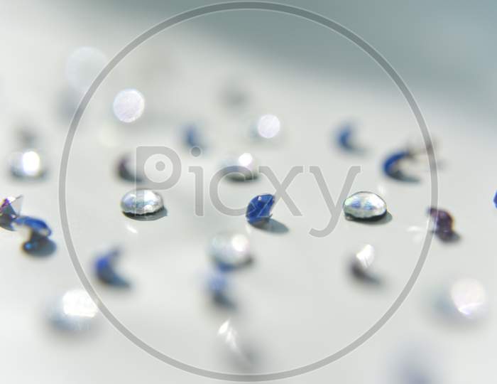 Rhinestones Of Different Colors On The White Background. Handcraft Concept. Selective Focus.