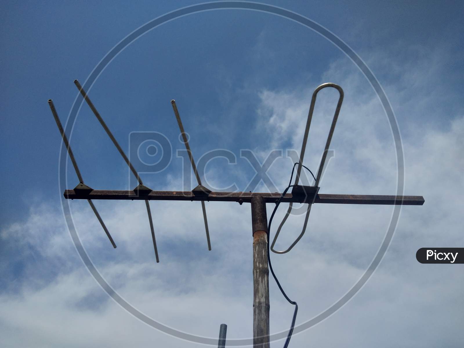 A TV antenna with blue sky, in day time