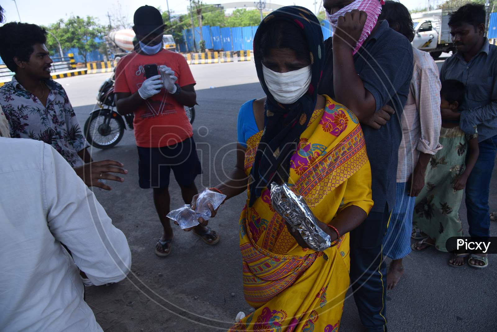 a migrant worker woman collects food packets being distributed by some donors as they couldn't find food and work during nationwide lockdown amid coronavirus pandemic, April 8,2020, Hyderabad.