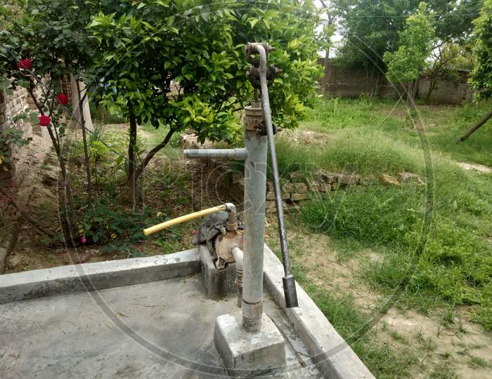 A water tap in village life with green plants in background