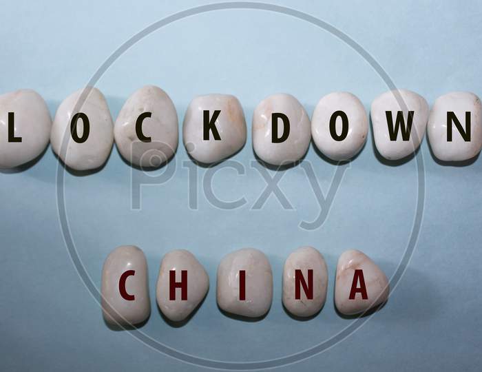 Concept Corona Virus. Lock Down China As A Text With Letters On White Royal Sapphire Rock Pebbles, Template Against A Blue Background