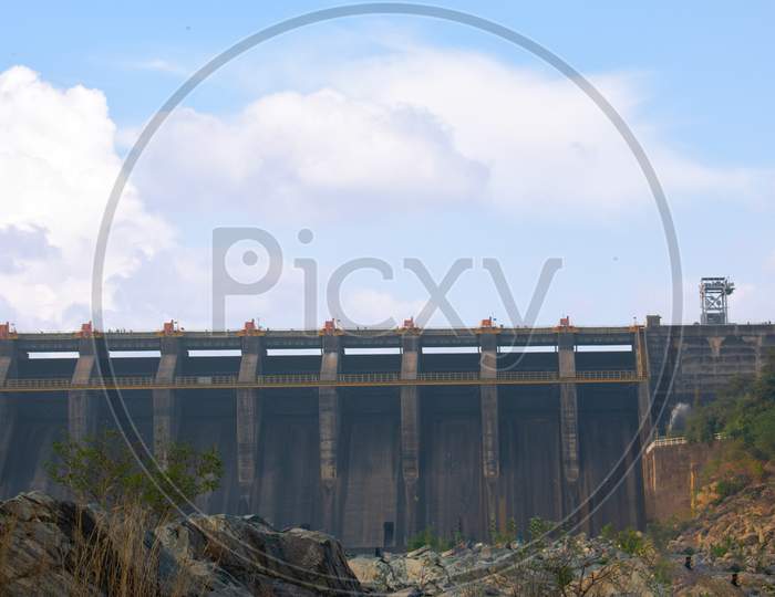 a image of water gates in a dam with beautiful clouds 