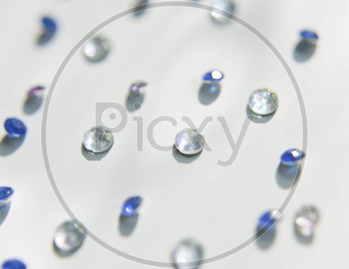 Rhinestones Of Different Colors On The White Background. Handcraft Concept. Selective Focus.