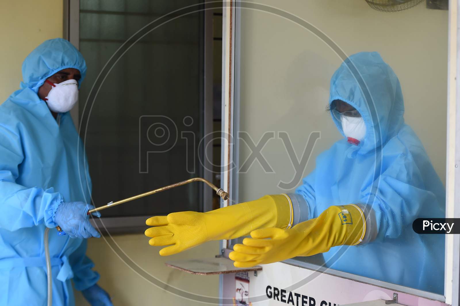 Medics wearing protective suits get sanitised after collecting swab samples for the COVID-19 test in Chennai