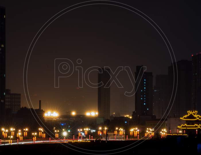 Xi'An City Wall At Night With Chinese Letters On The Wall Which Translates "Government Bay Passenger Transport Station"